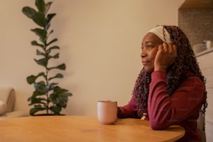 uma mulher sentada em uma mesa falando ao celular