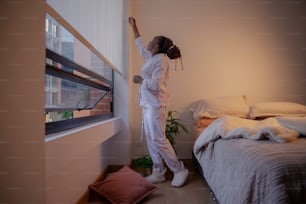 una mujer con un traje blanco de pie frente a una ventana