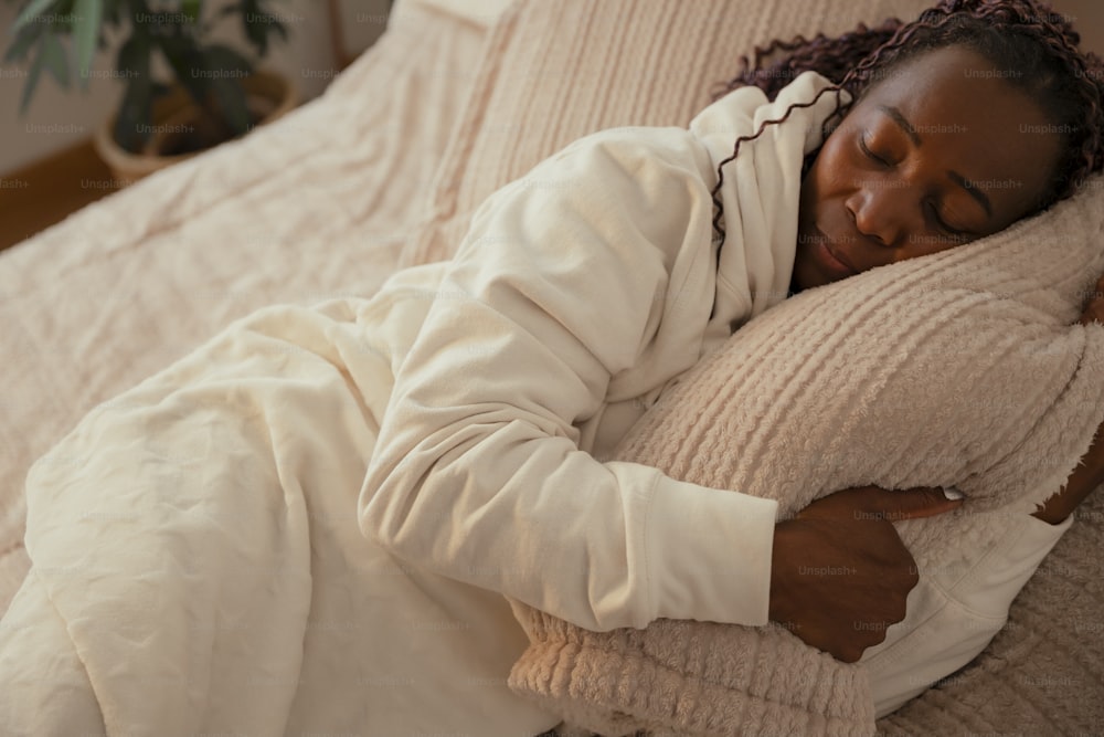 a woman laying on a bed with a pillow