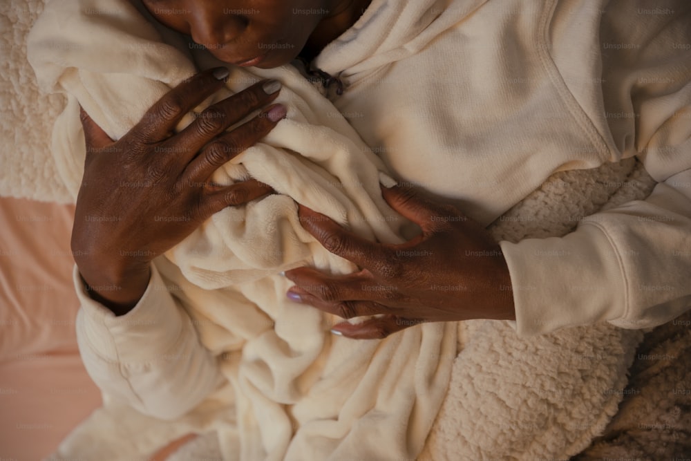 una donna che tiene in braccio un bambino avvolto in una coperta