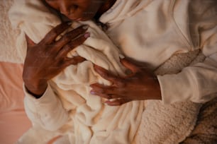 eine Frau, die ein in eine Decke gewickeltes Baby hält