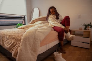 a woman sitting on a bed in a room
