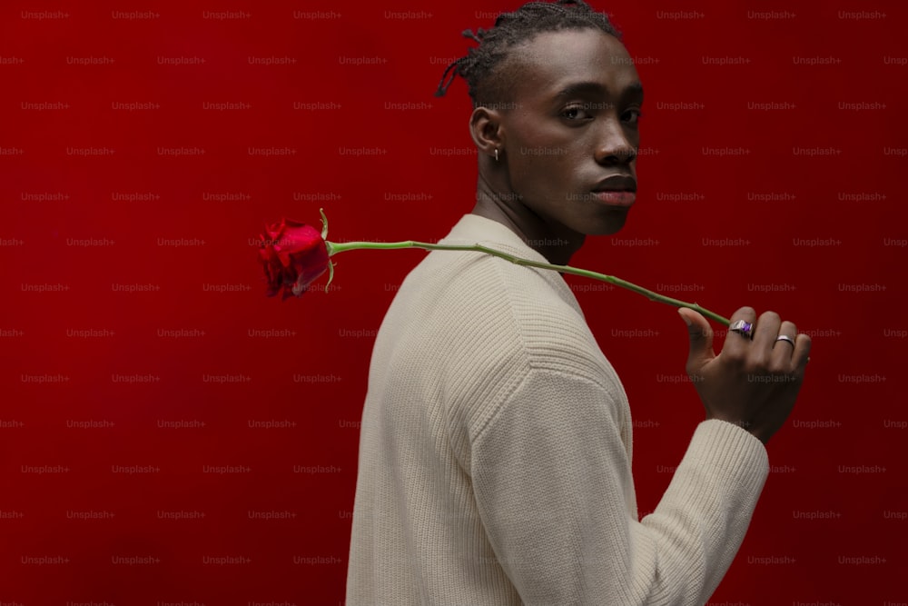 a man holding a single rose in his hand