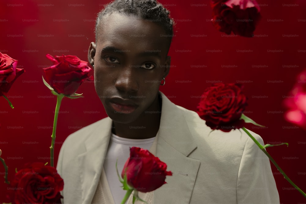 um homem de jaqueta branca cercado por rosas vermelhas