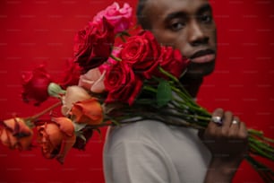 a man holding a bunch of flowers in front of his face