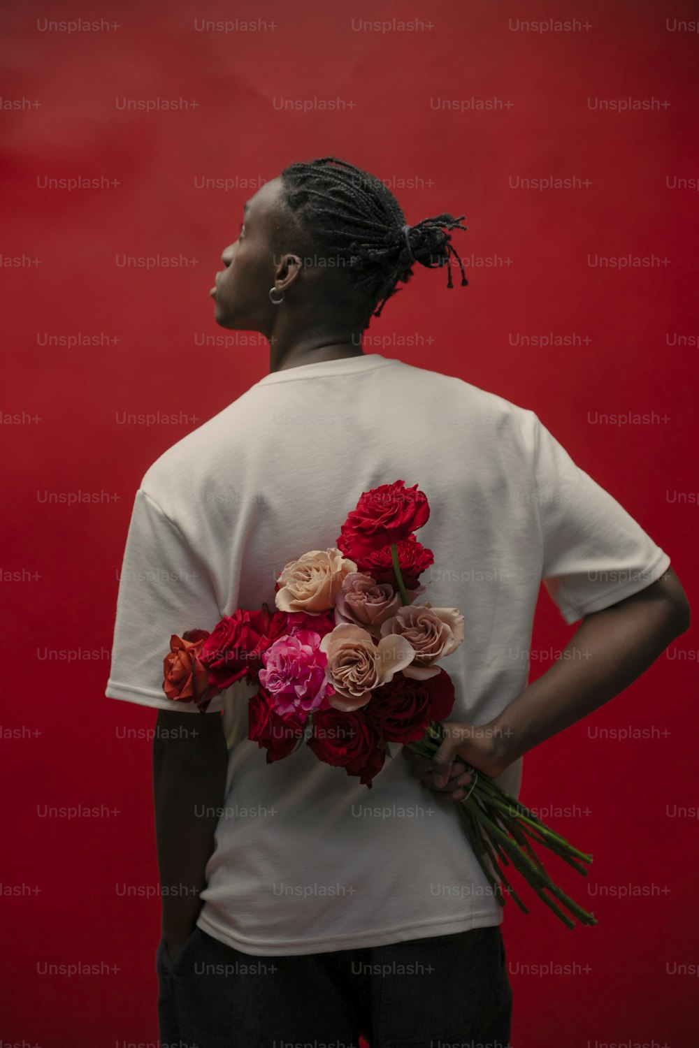 a woman with dreadlocks holding a bunch of flowers
