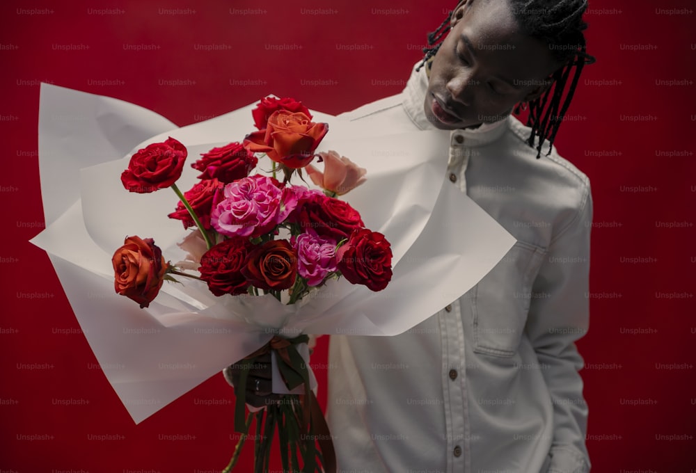 a man with dreadlocks holding a bouquet of roses