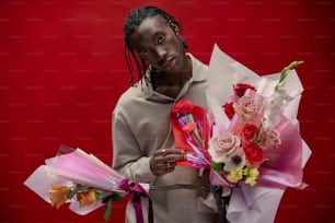 a man with dreadlocks holding a bouquet of flowers