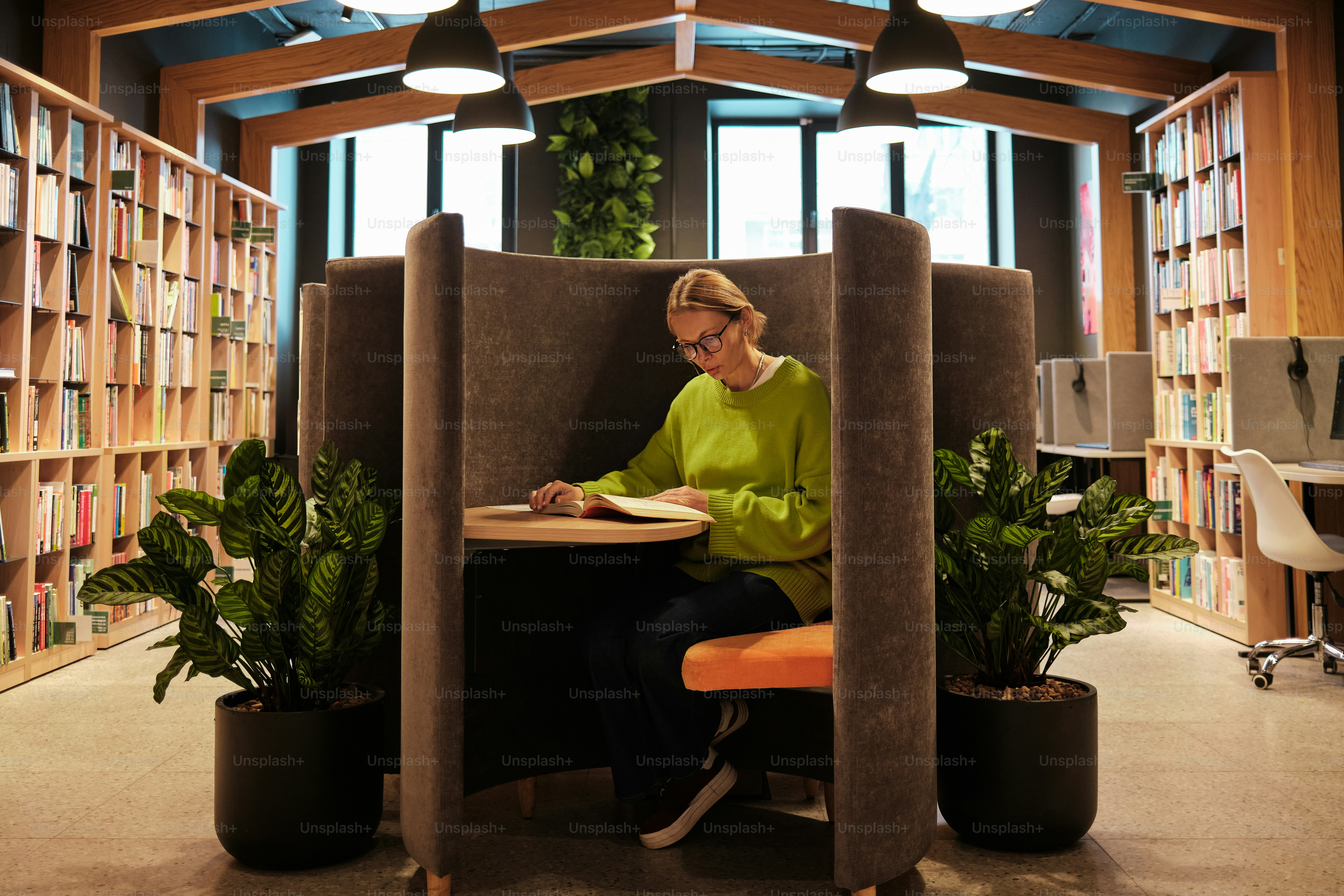 Woman reading in a modern library study booth.