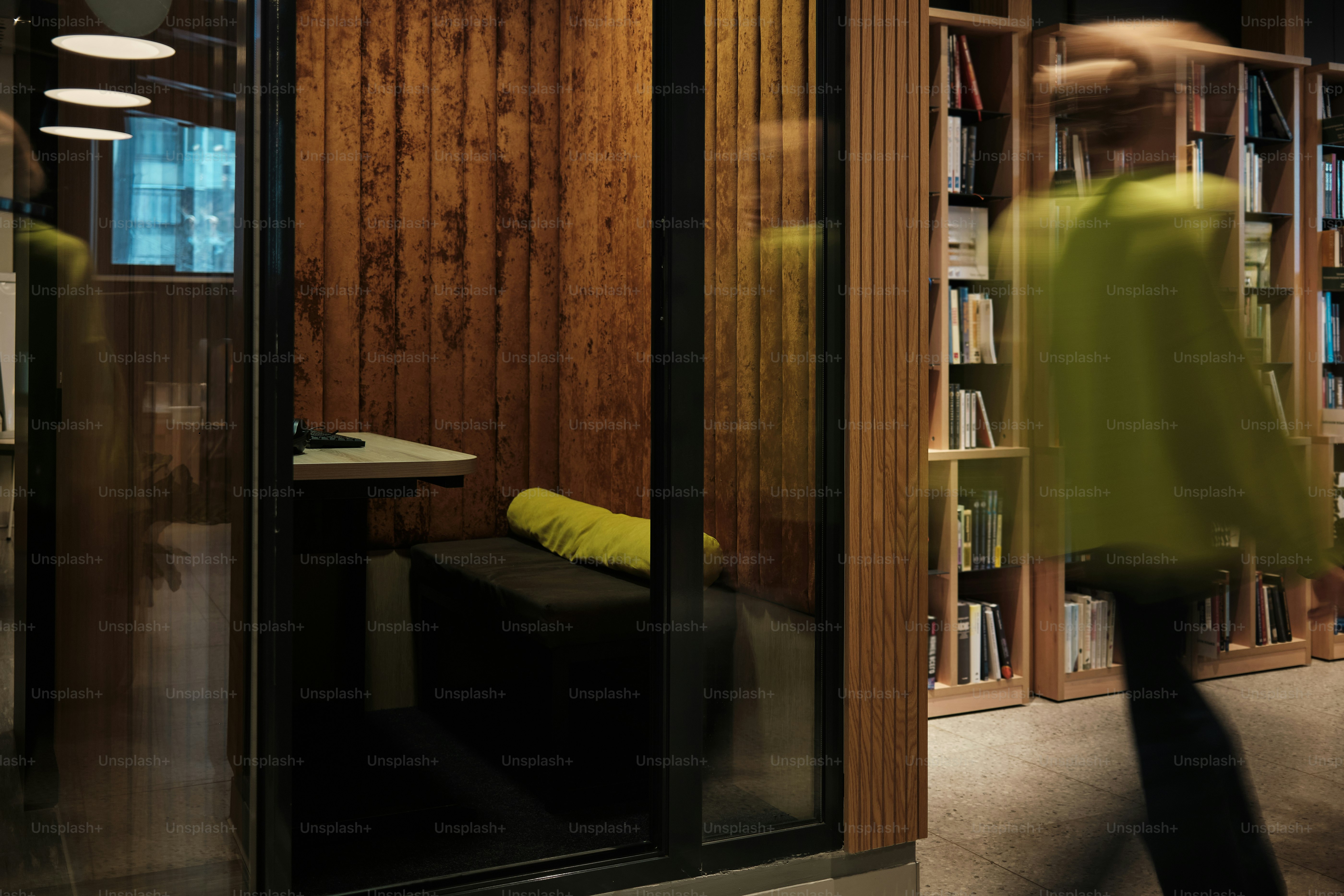 Person walks past a modern study booth in library.