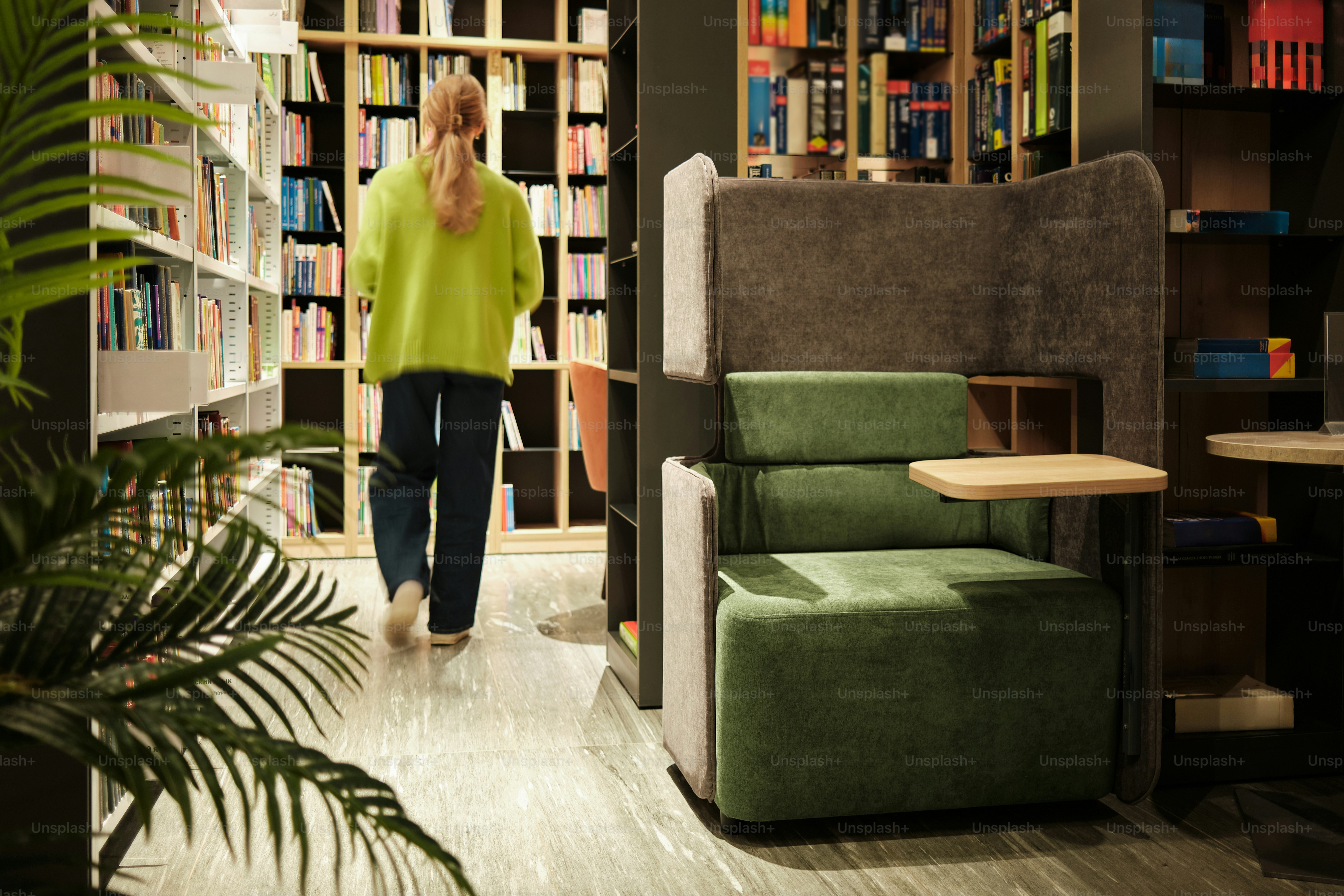 Mujer caminando en una biblioteca con estanterías