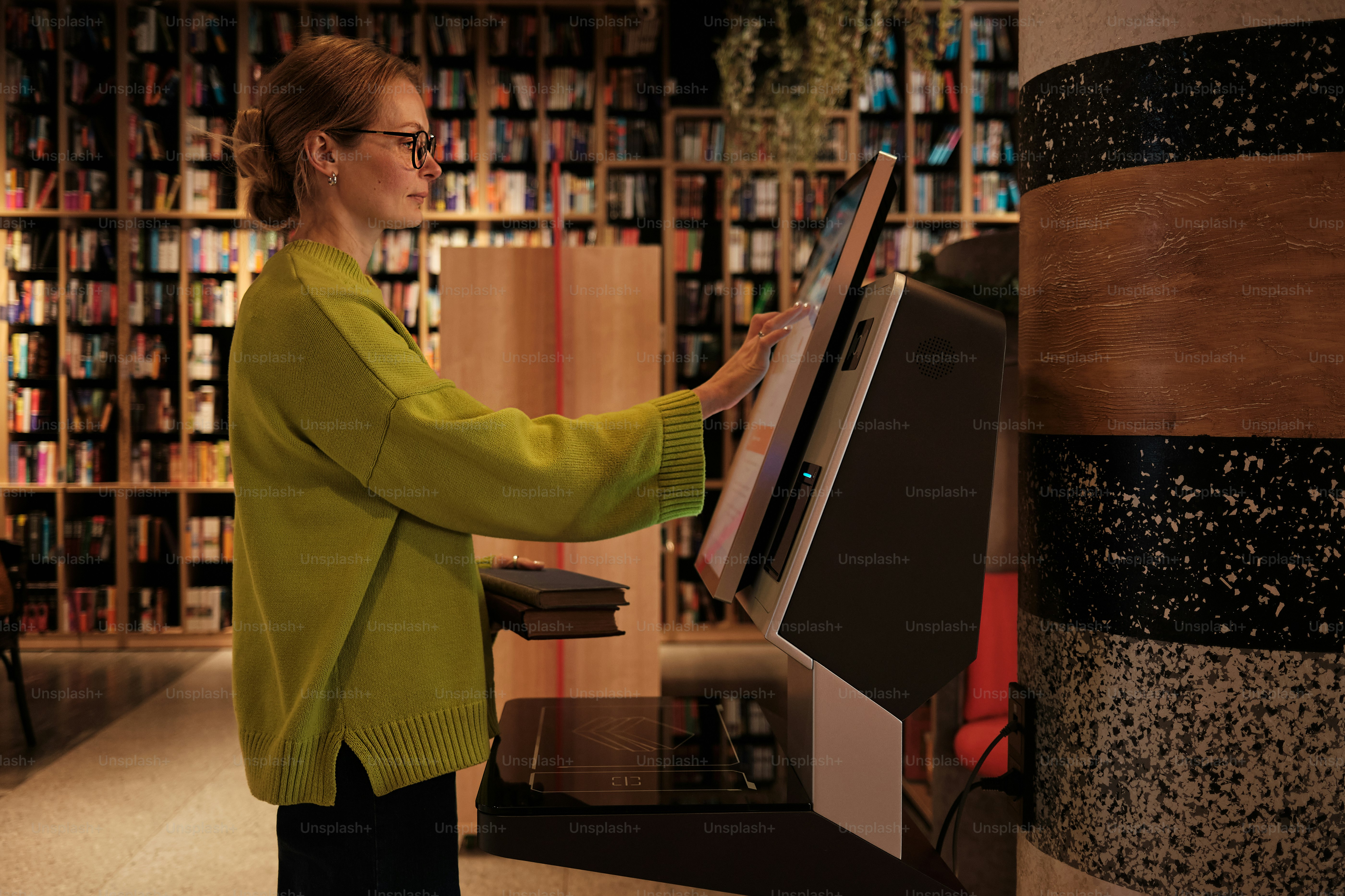 Woman uses interactive kiosk in a library.