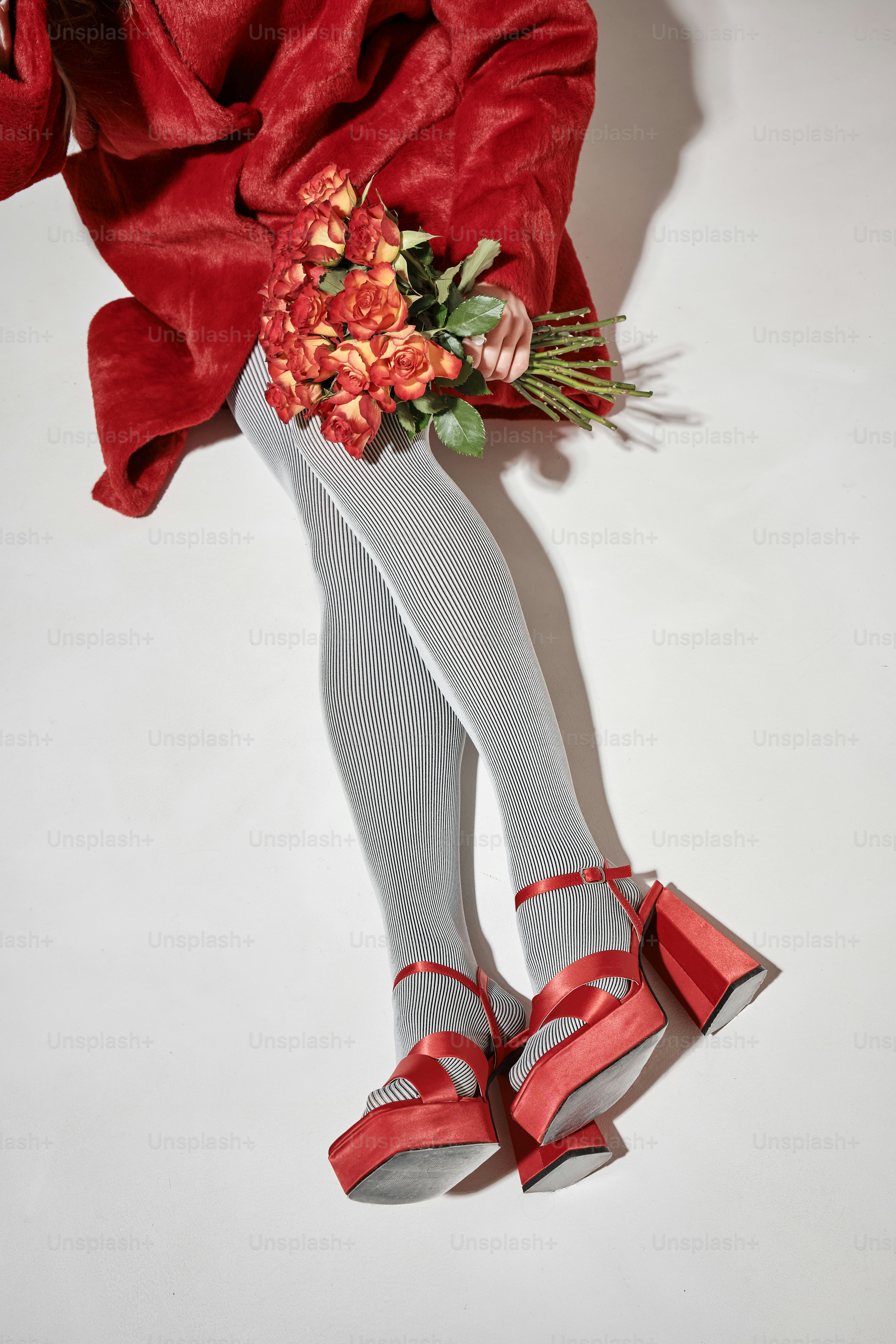 Woman in red dress holding bouquet with red shoes