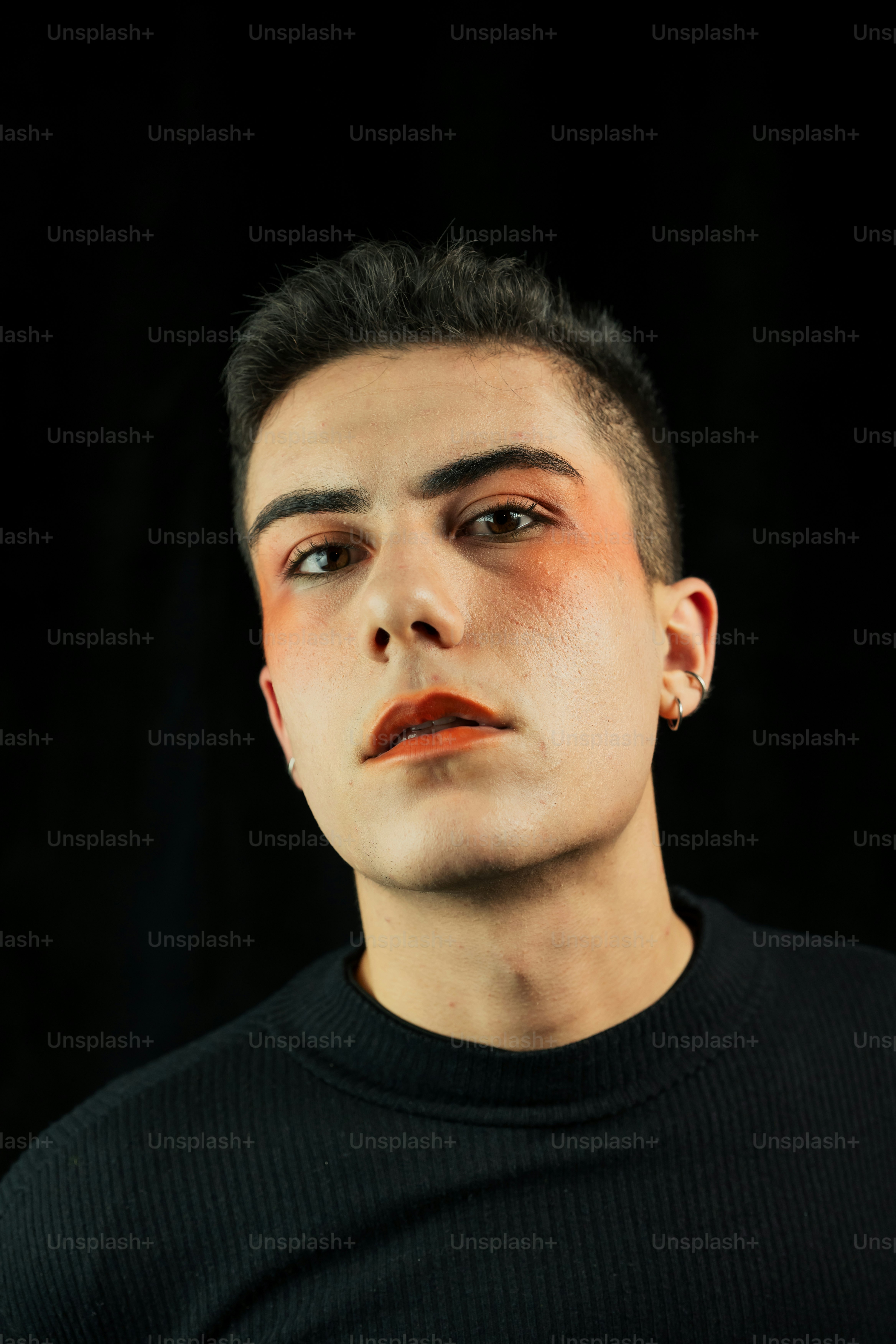 A person with dramatic orange eye and lip makeup.