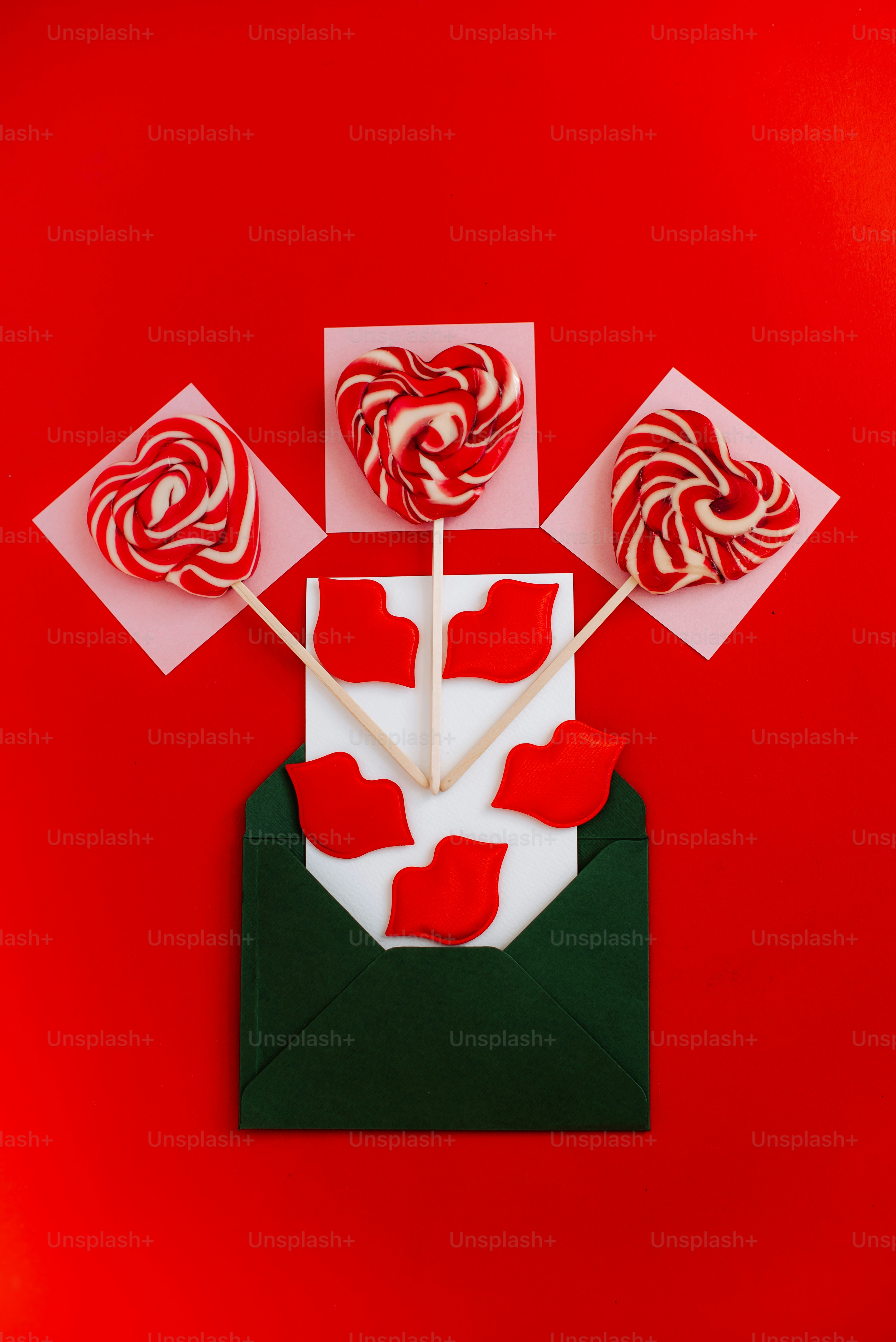 Heart-shaped lollipops and red lips on red background