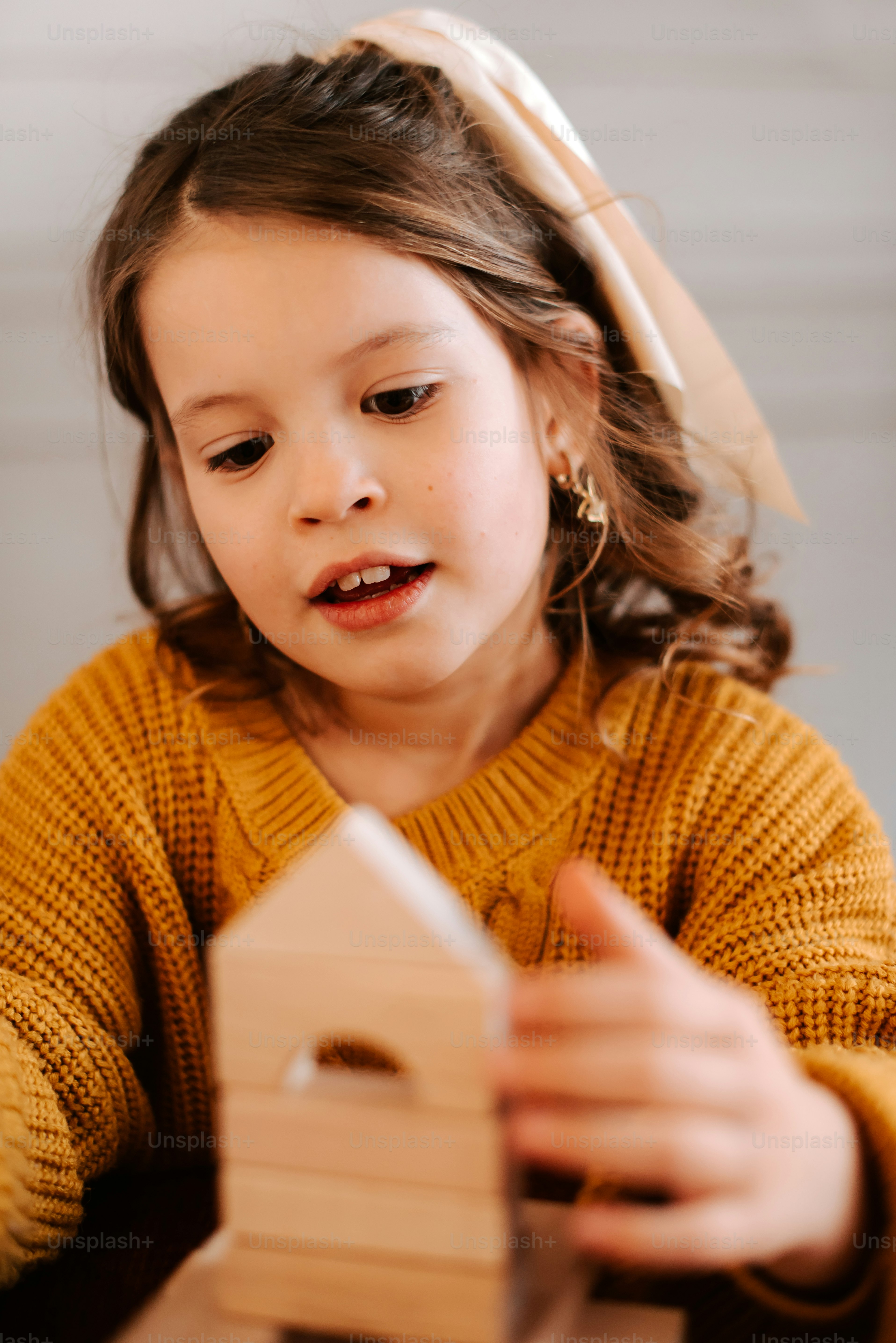A young girl building with wooden blocks