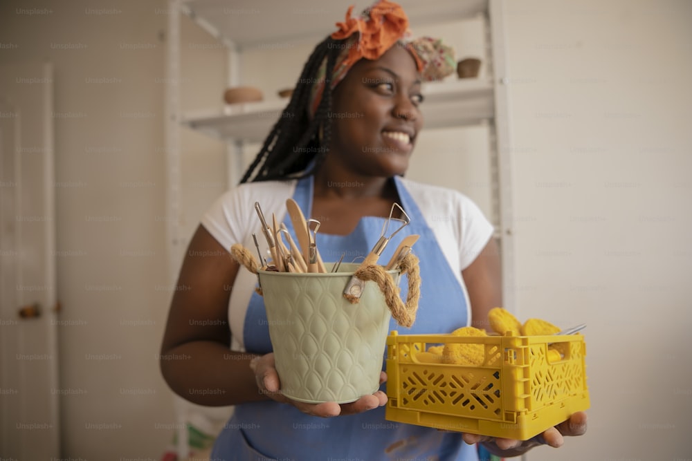 a woman holding a basket with sticks in it