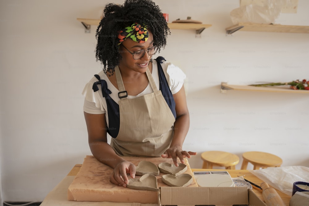 a woman in an apron is making something out of cardboard