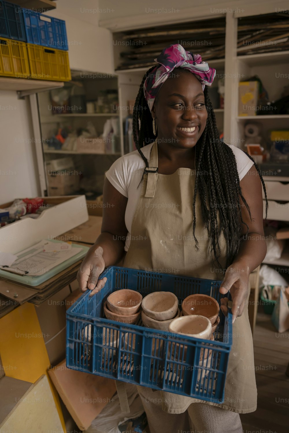 a woman holding a blue basket filled with pots