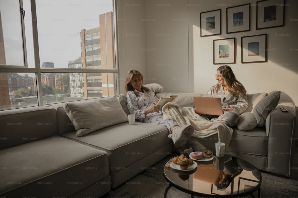 a couple of women sitting on top of a couch