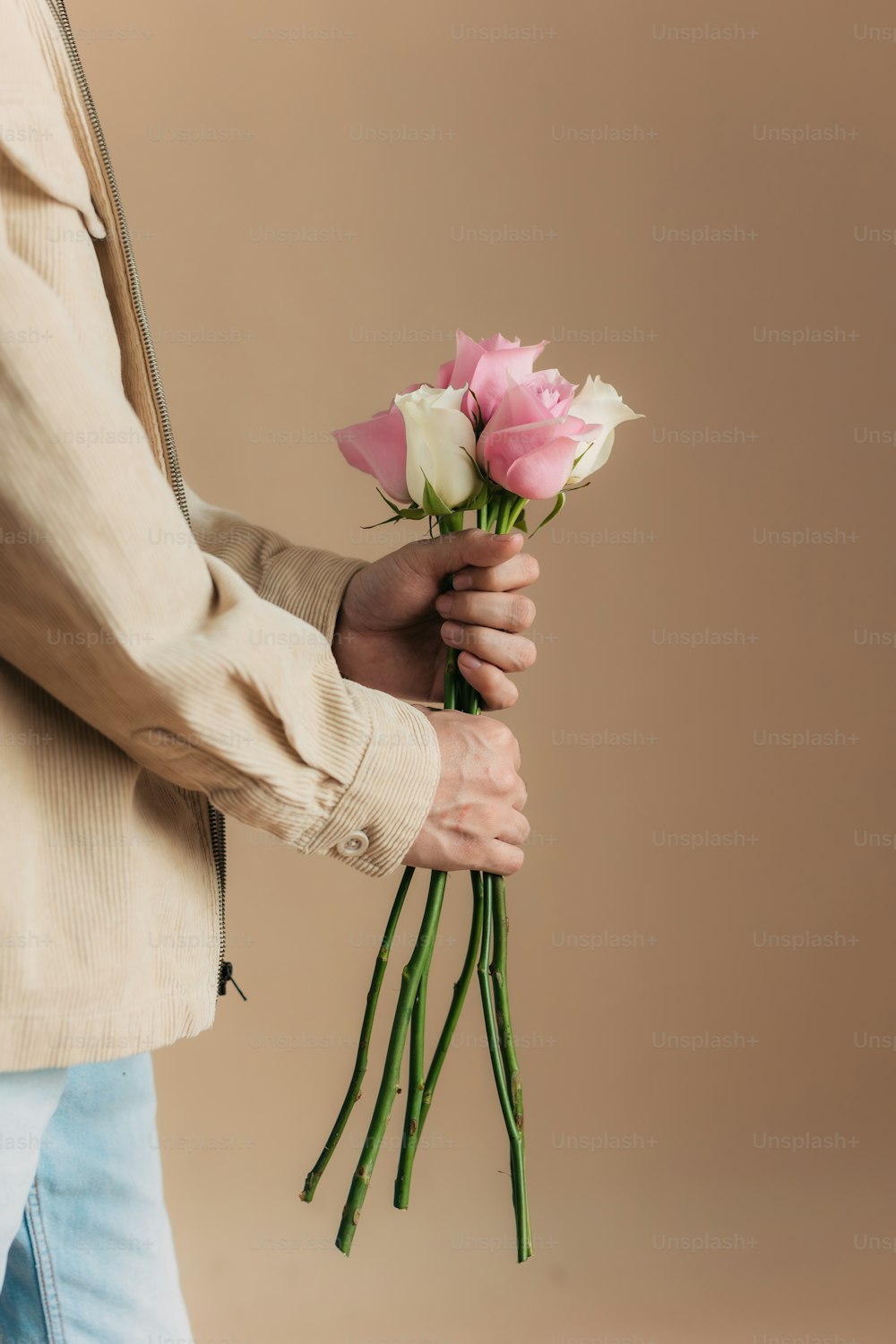a person holding a bunch of pink and white roses