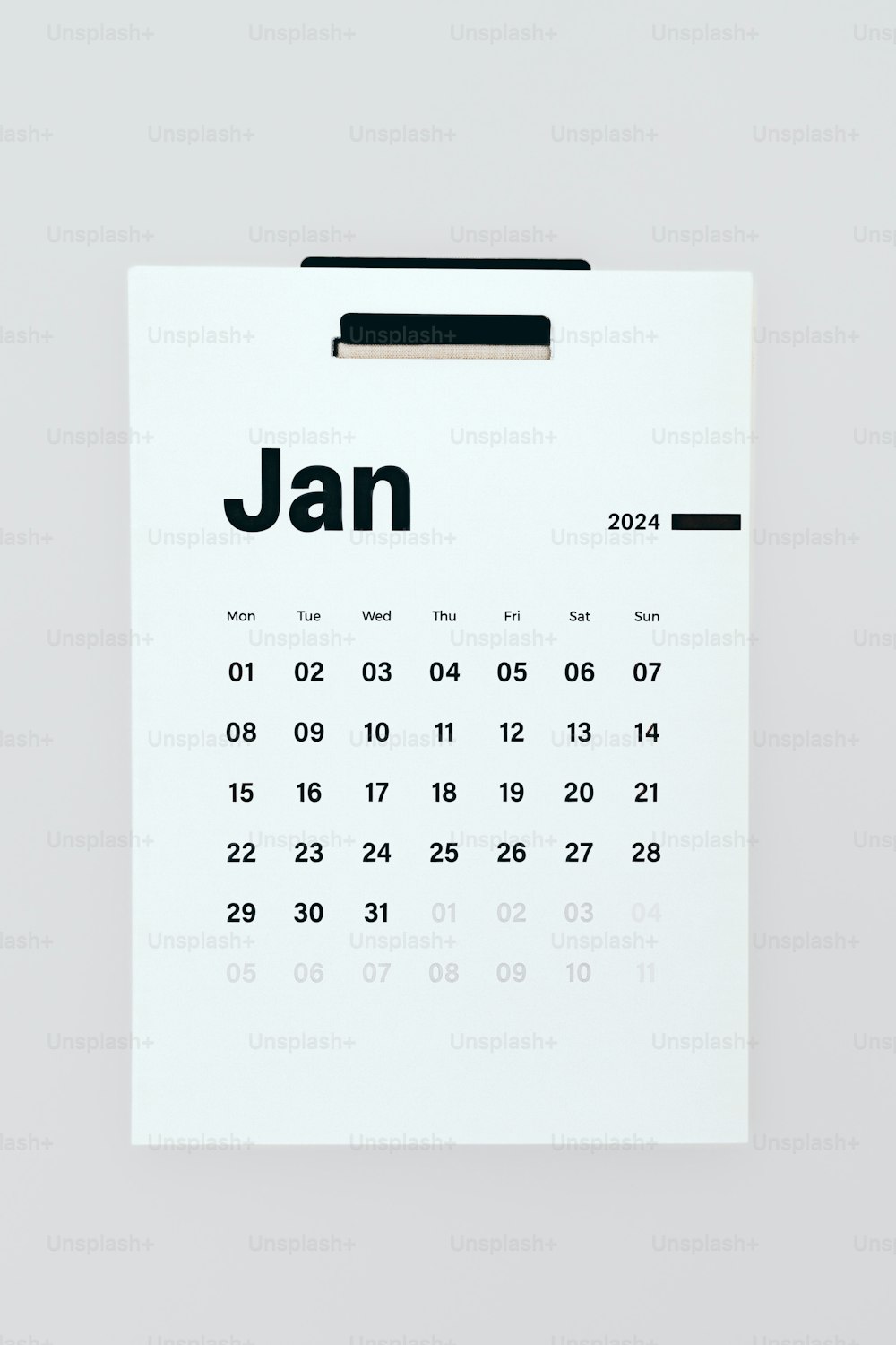 a calendar pinned to a white wall with the date jan on it