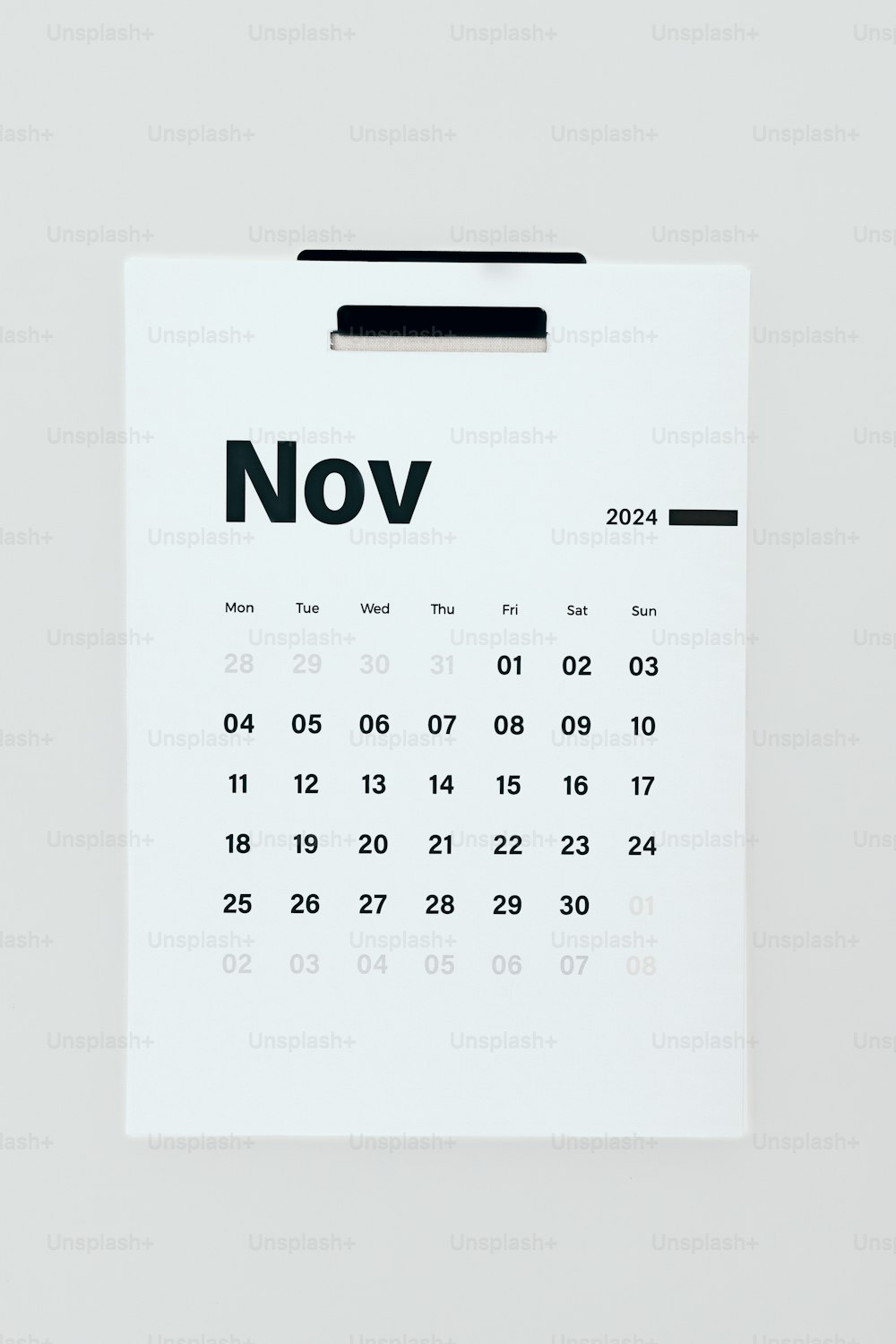 Un calendario clavado en una pared blanca con la palabra noviembre escrita en él