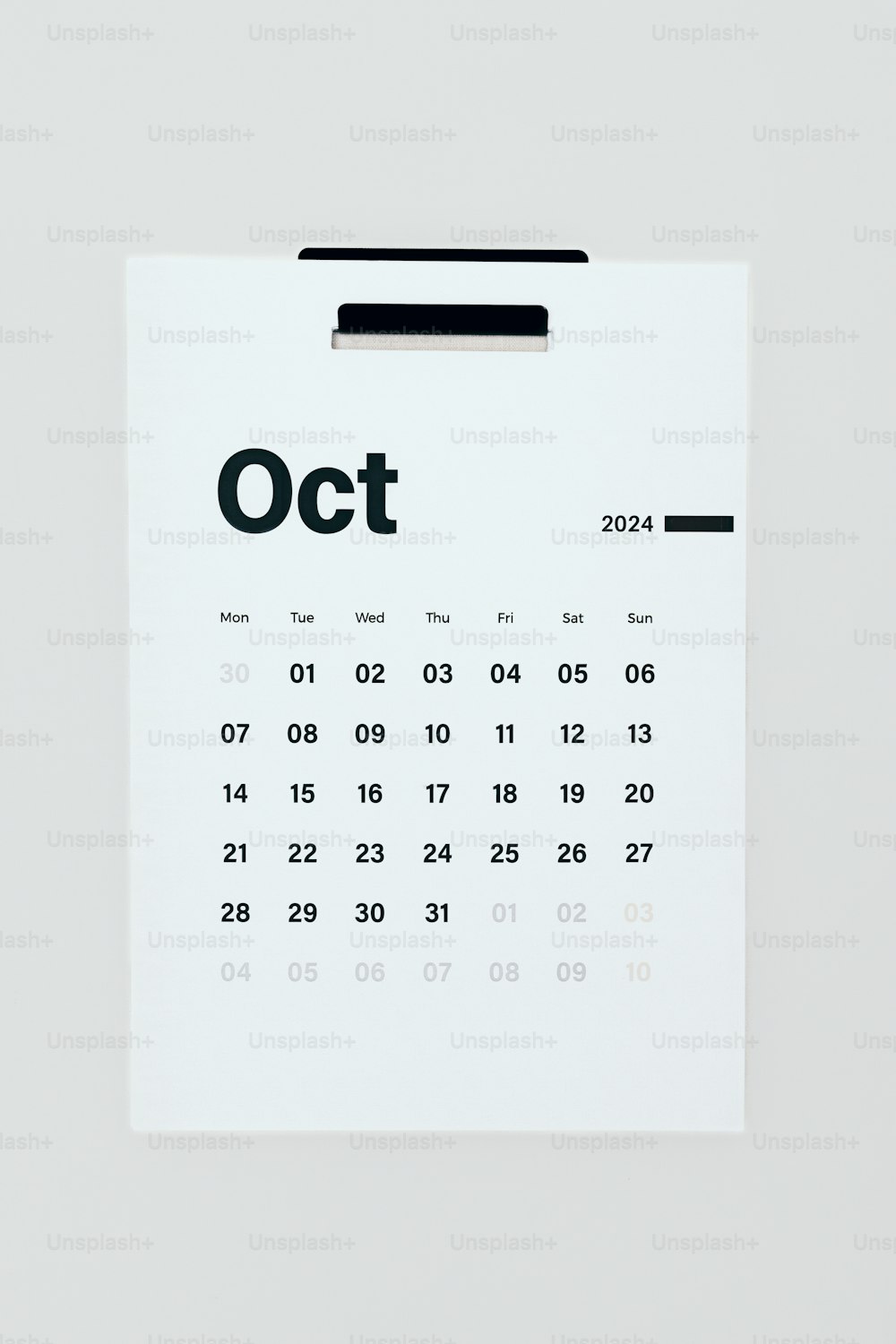 Ein Kalender, der an eine weiße Wand gepinnt ist