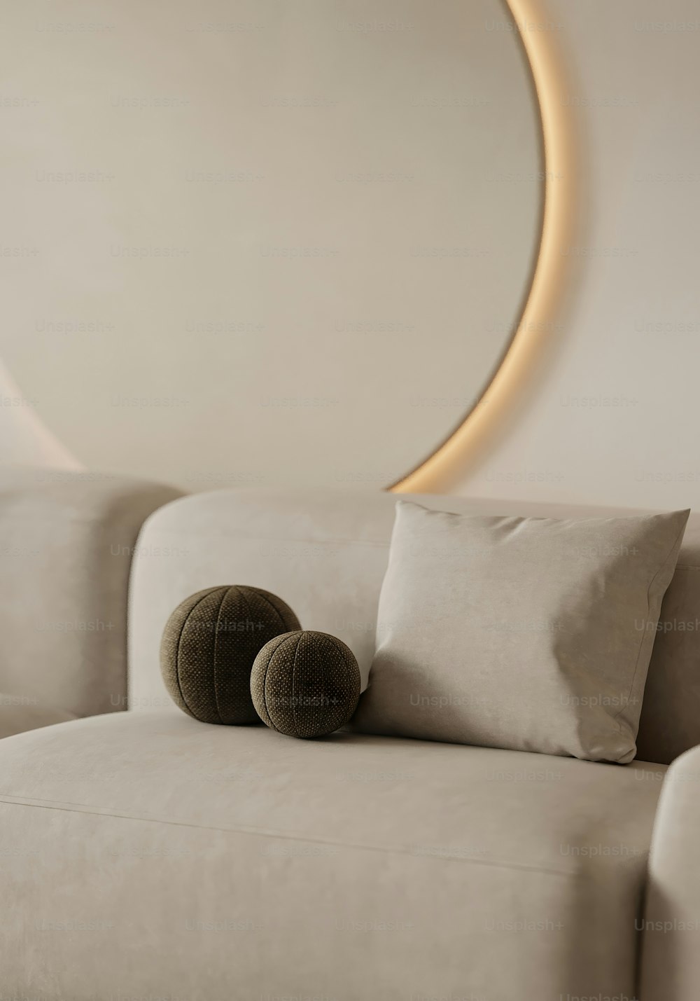 a couch with pillows and a round mirror behind it