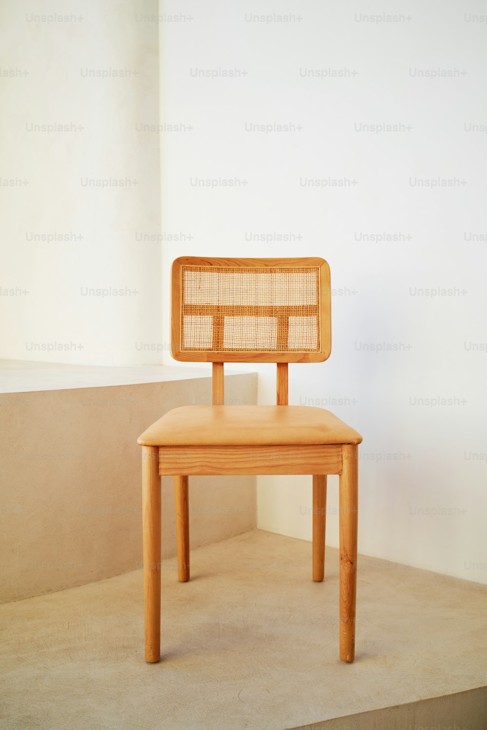 una sedia di legno seduta sopra un pavimento di cemento