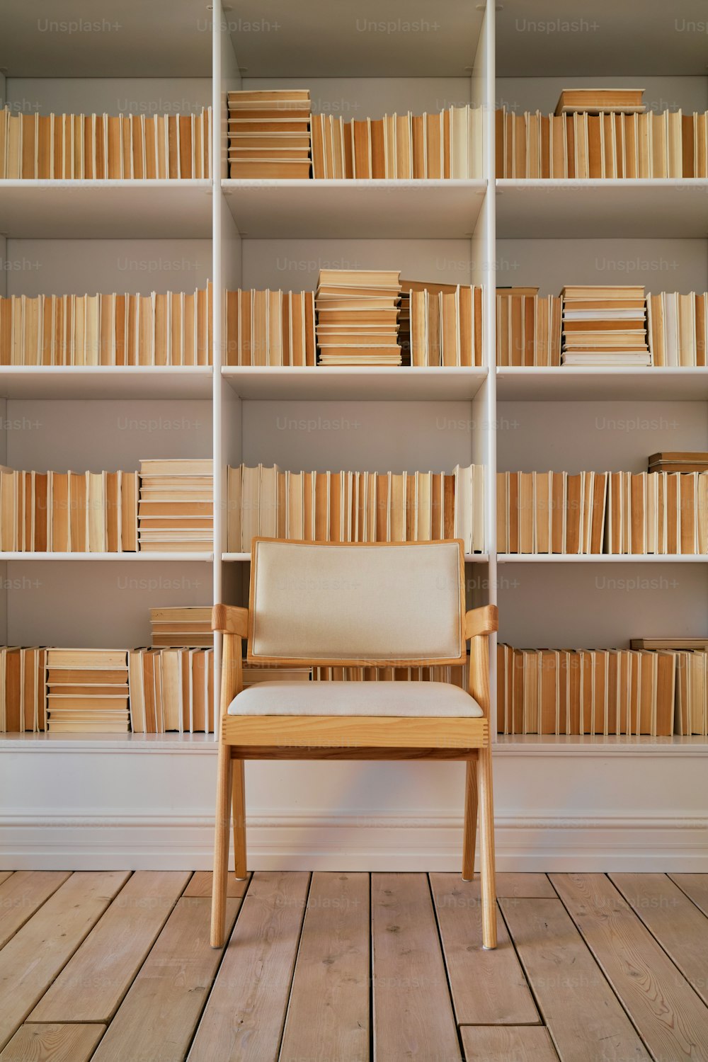 una silla sentada frente a una estantería llena de libros