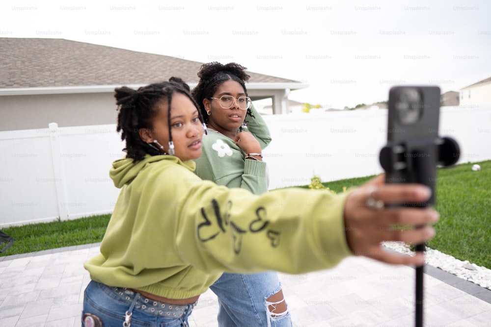 two women taking a picture with a cell phone