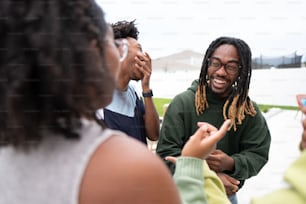 a man with dreadlocks talking to a group of people