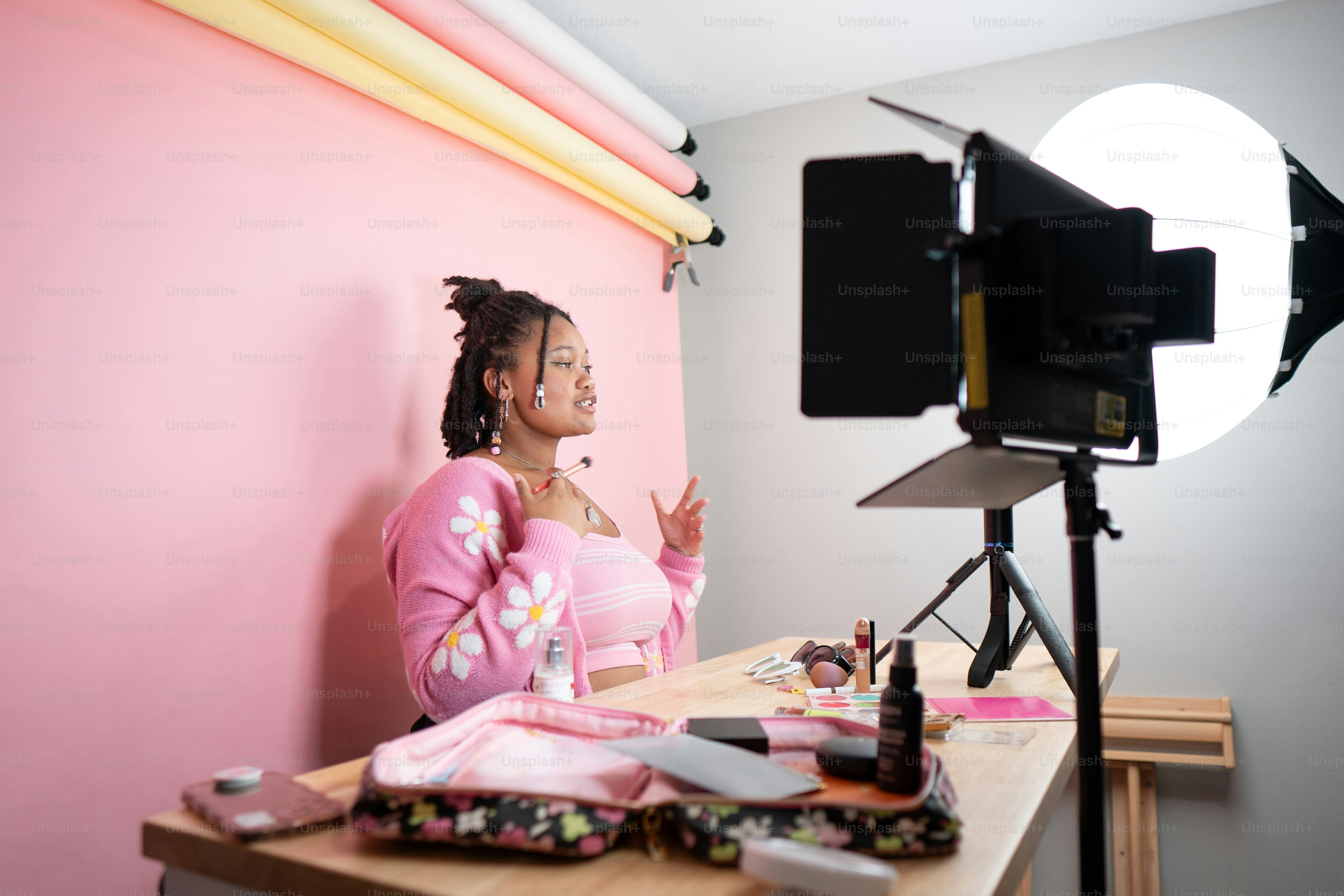 a woman sitting at a desk in front of a camera