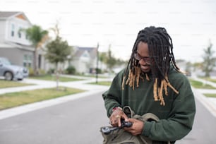 a man with dreadlocks looking at his cell phone