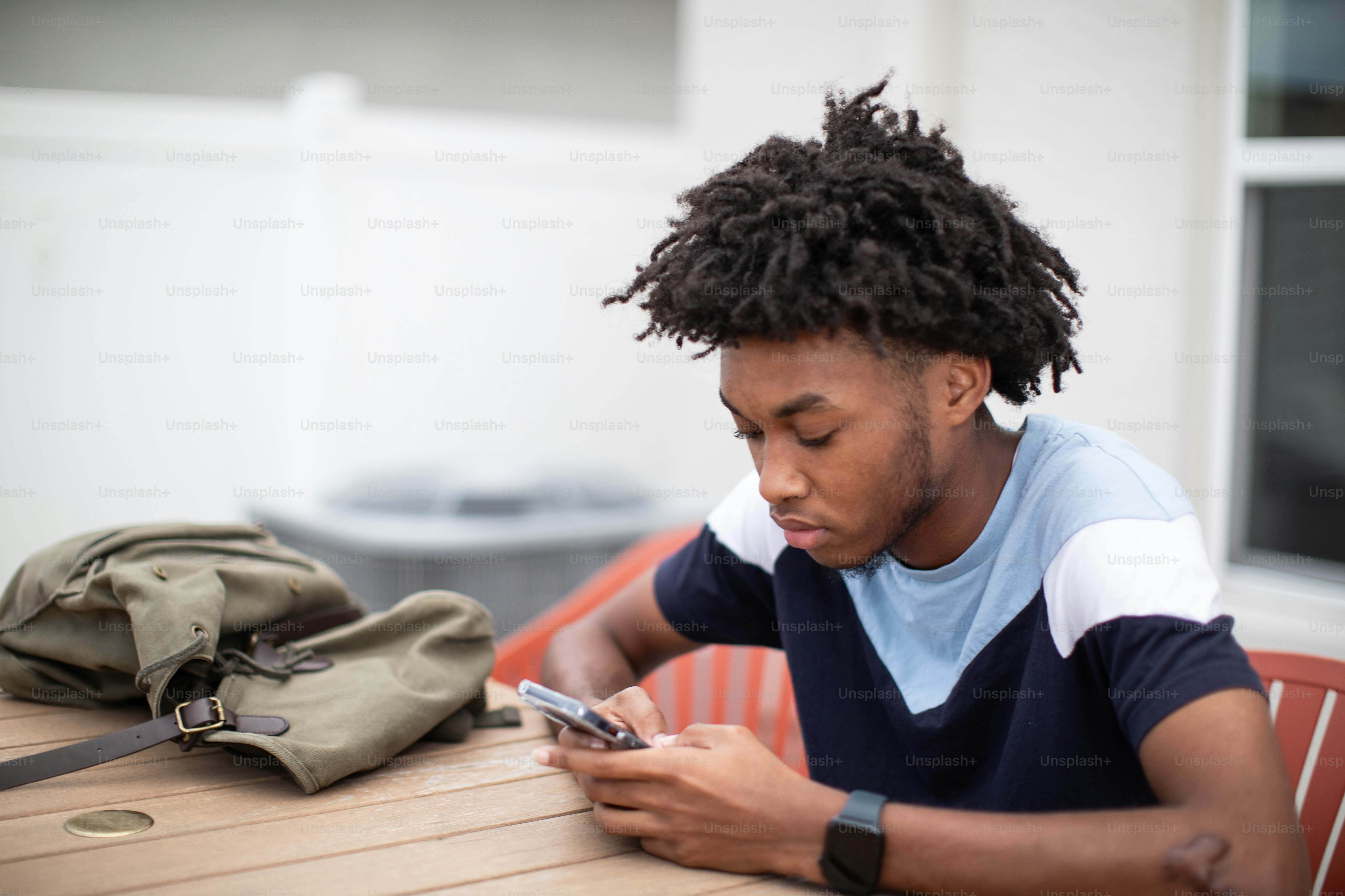 a man sitting at a table looking at his cell phone