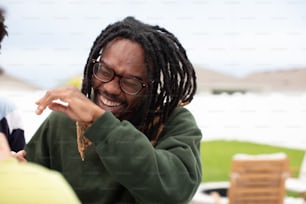 a man with dreadlocks eating a piece of food