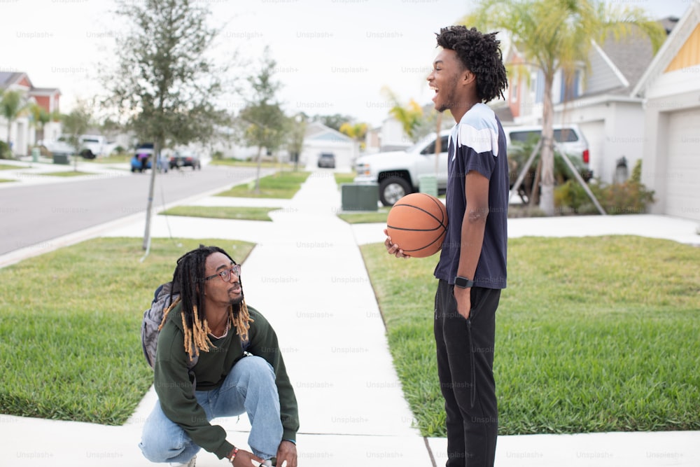 a man holding a basketball next to a woman on a sidewalk