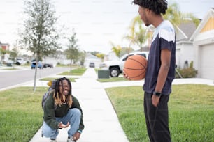 a young man holding a basketball next to another young man