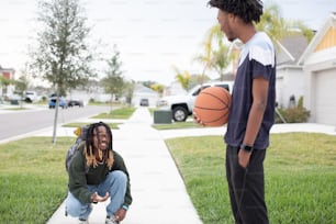 Un joven sosteniendo una pelota de baloncesto junto a otro joven