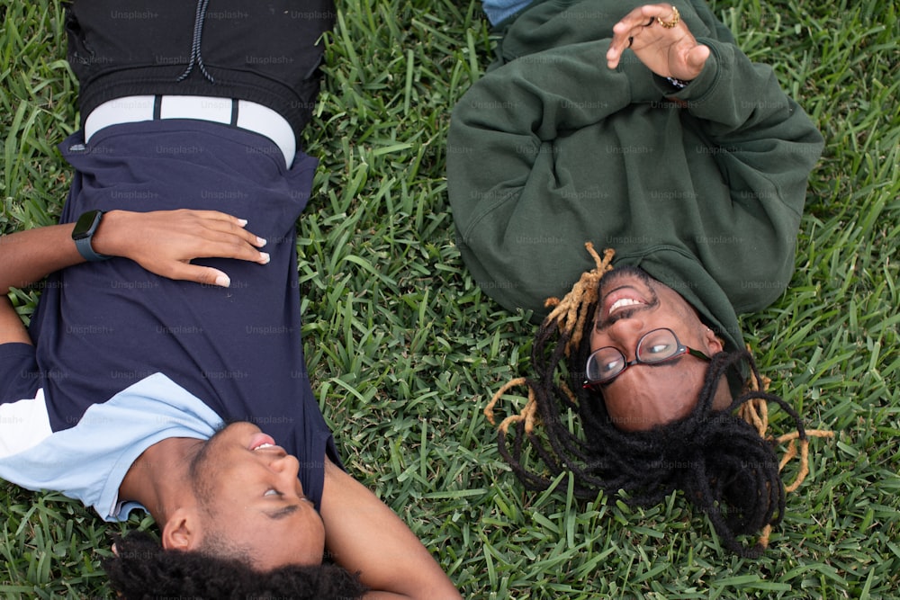 un couple de personnes allongées sur un champ verdoyant