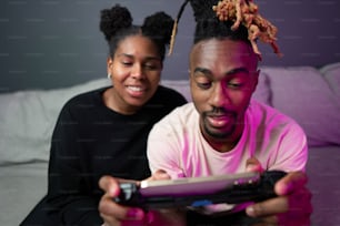 a man and woman sitting on a couch playing a video game