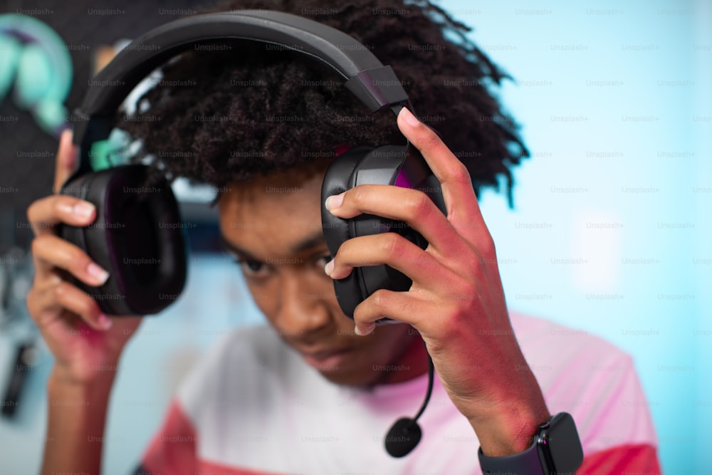 a young man wearing headphones holding a pair of headphones