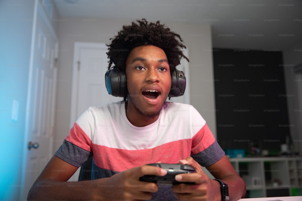um jovem usando fones de ouvido segurando um controle de videogame