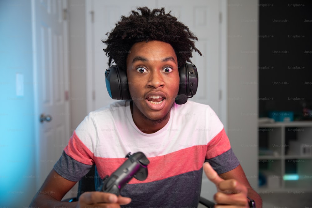 Ein junger Mann mit Kopfhörern, der einen Videospiel-Controller hält