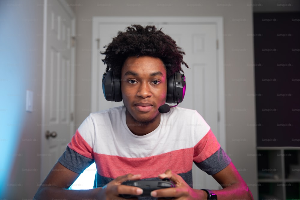 um jovem usando fones de ouvido e segurando um controle de videogame