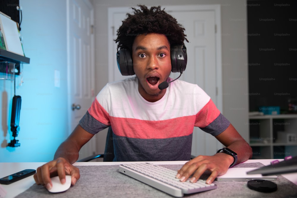 a young man wearing headphones and using a computer keyboard