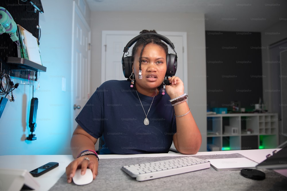 a woman sitting at a desk with headphones on