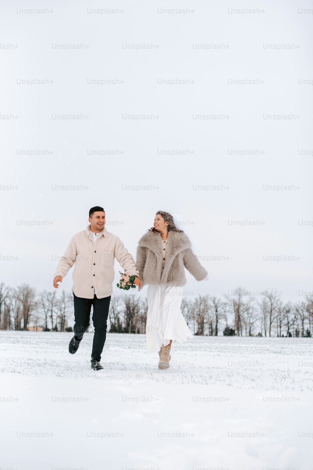 un homme et une femme marchant dans la neige
