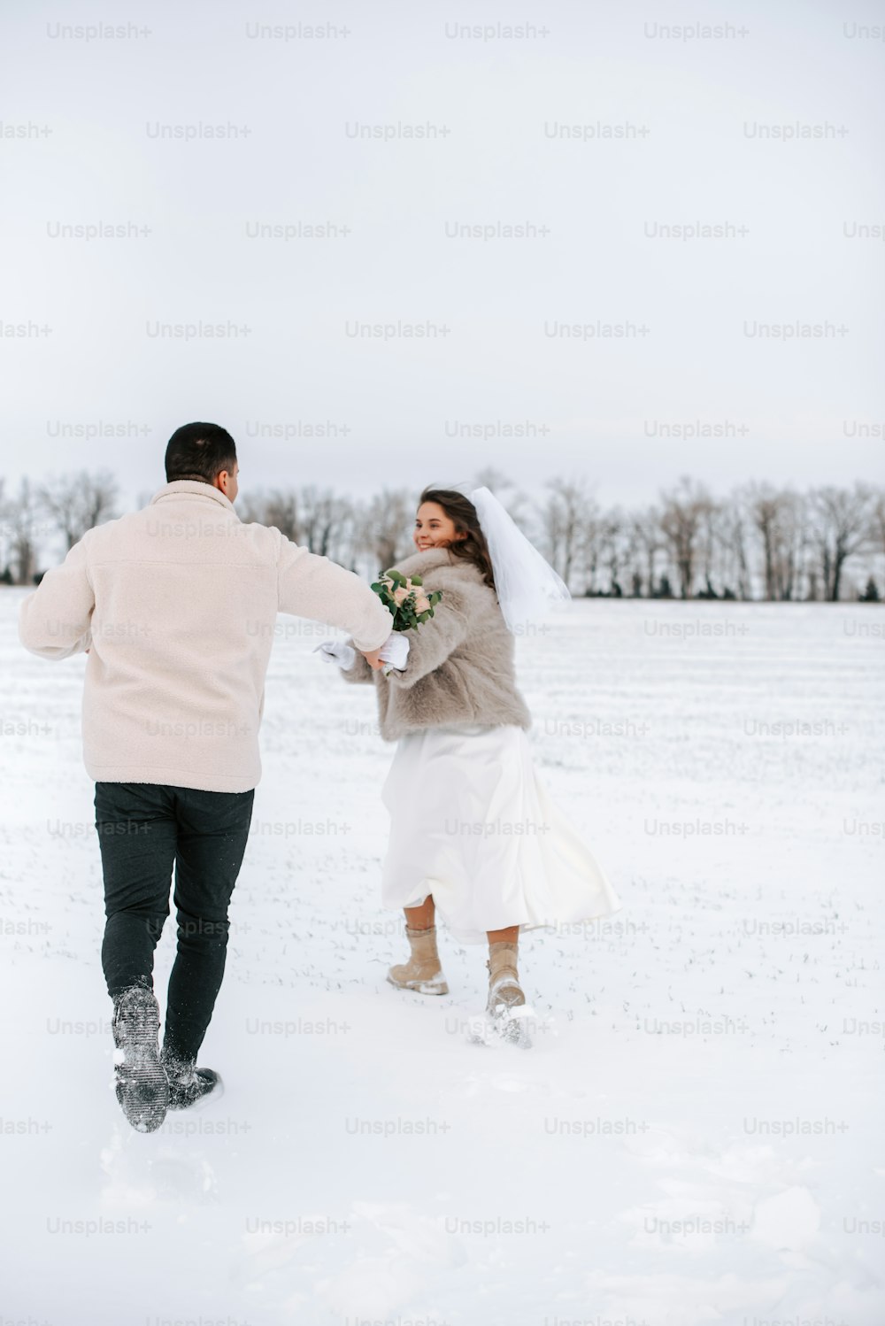 una novia y un novio caminando en la nieve